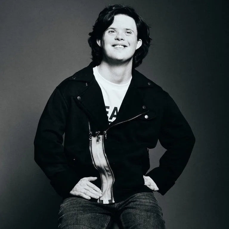 A young man smiling in a black motocross jacket fitted with a ZipperBuddy