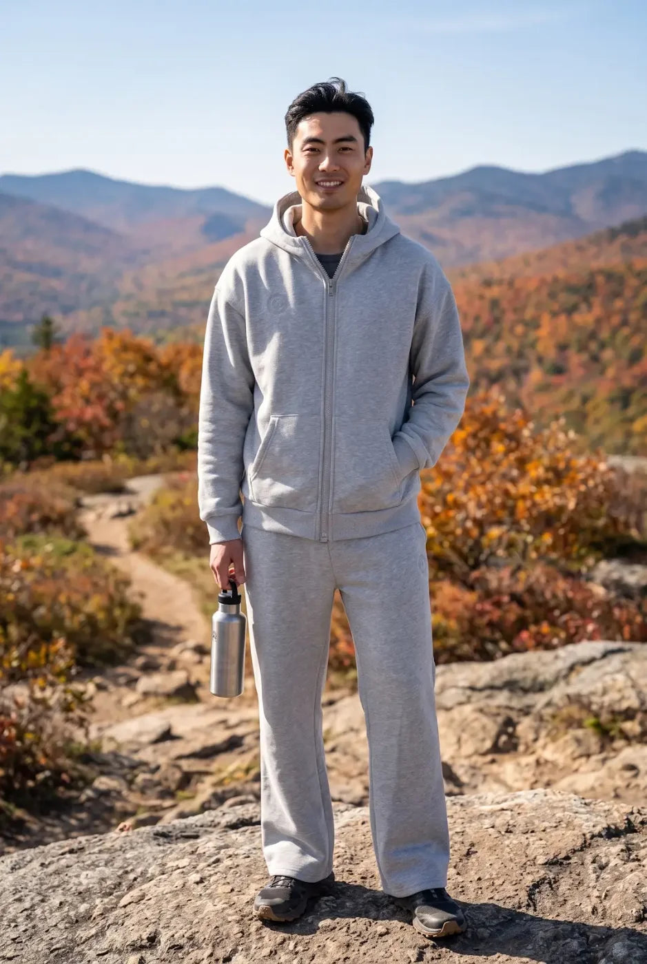 A man at a mountain overlook in the gray FREEDOM Hoodie and Jogger