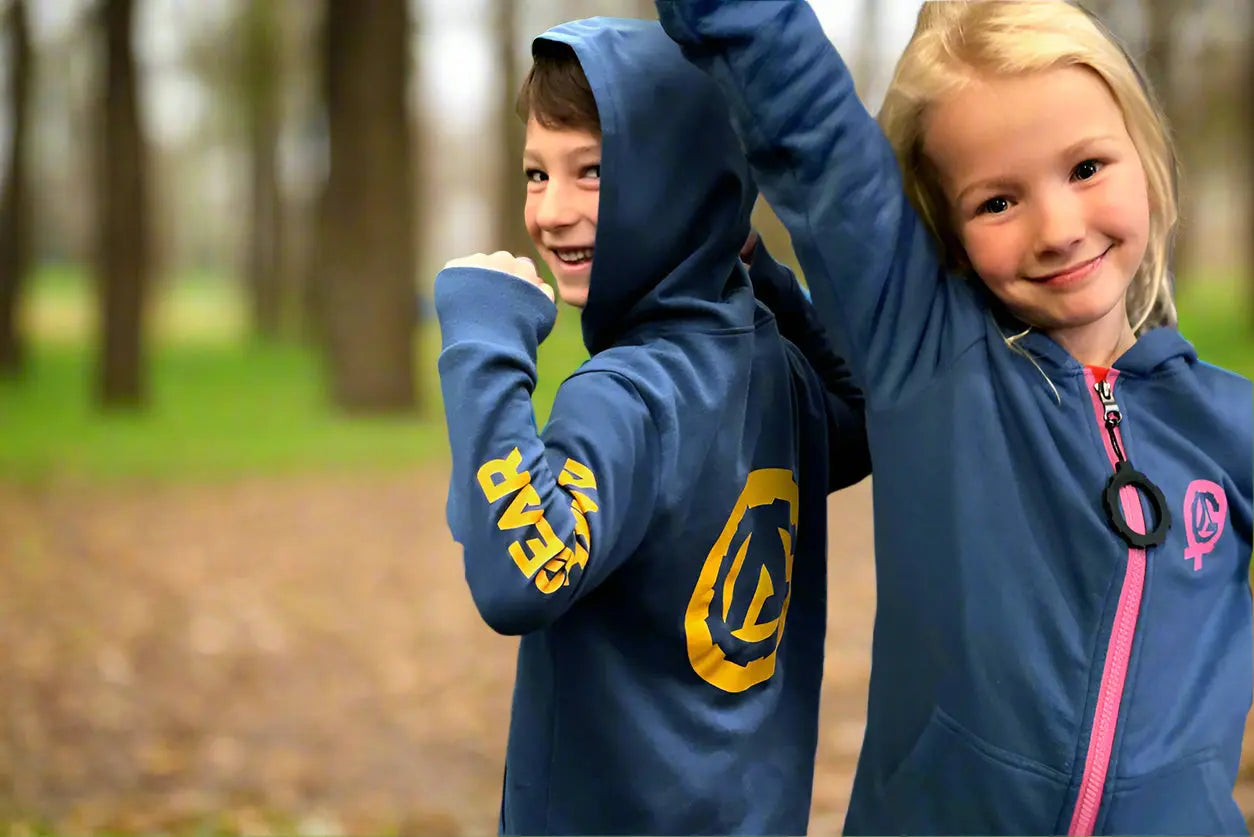Two kids in blue MagZip hoodies in a park