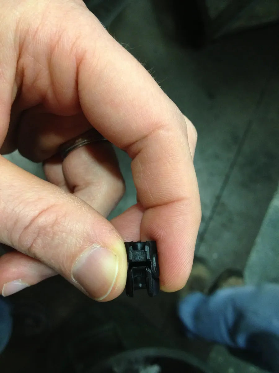 A small hand-finished prototype base held between two fingers